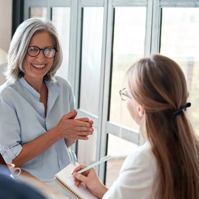 female mentor training young apprentices at group office meeting